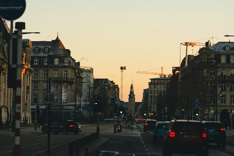City avenue at dusk with a clock tower in the distance, Luxembourg City