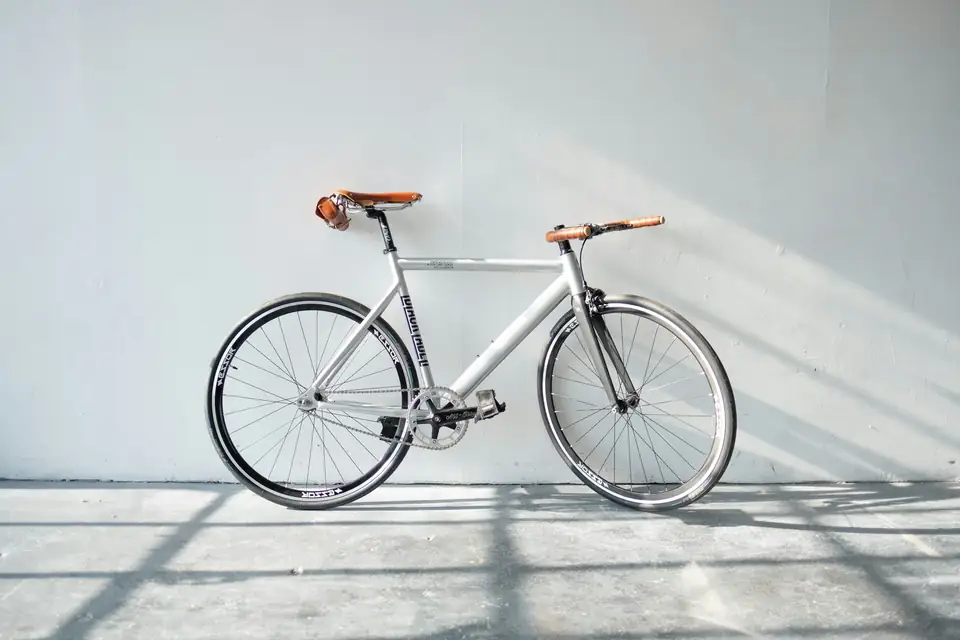 White bicycle leaning against a wall