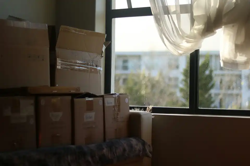 Moving boxes stacked near a window
