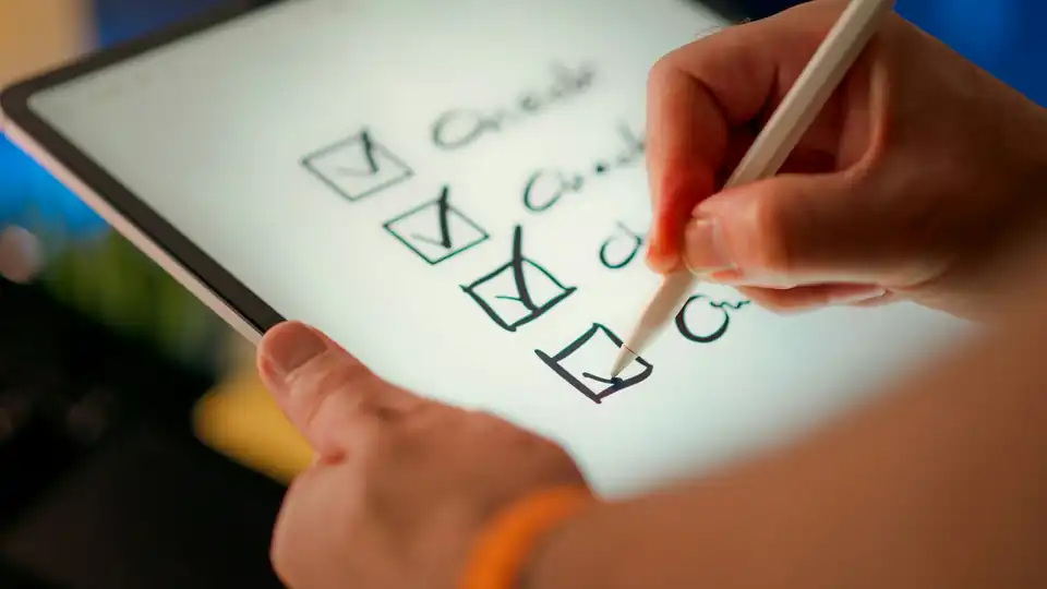 Hand ticking a checklist on a tablet