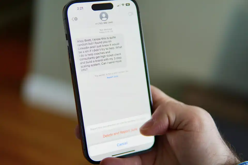 Hand holding a smartphone with a text conversation