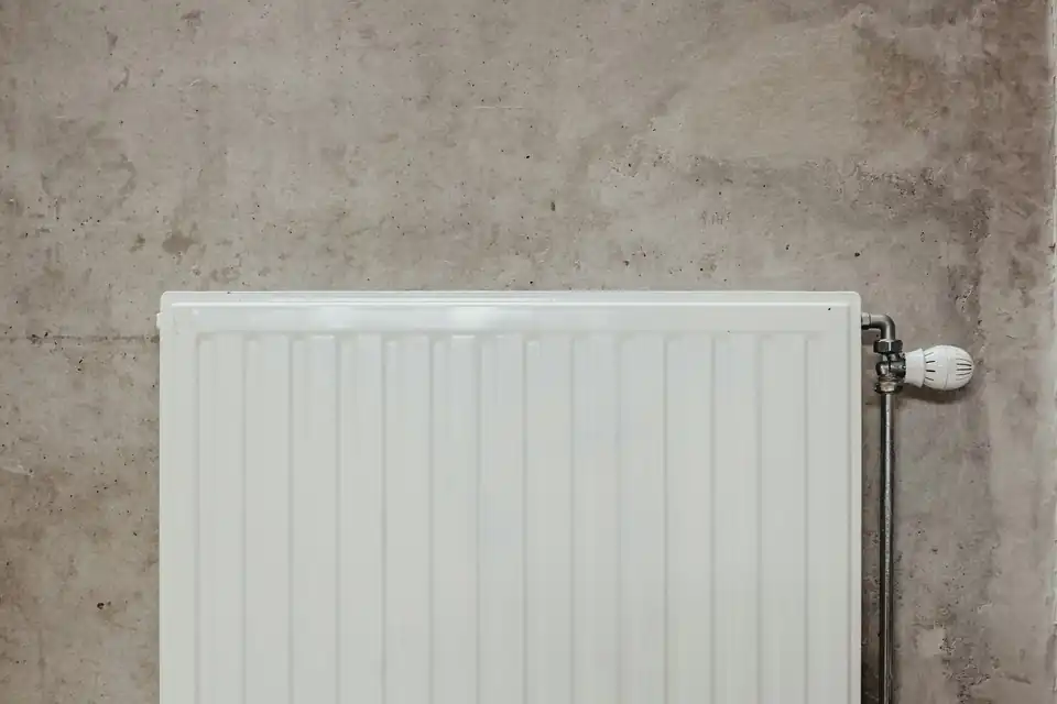White radiator against a concrete wall